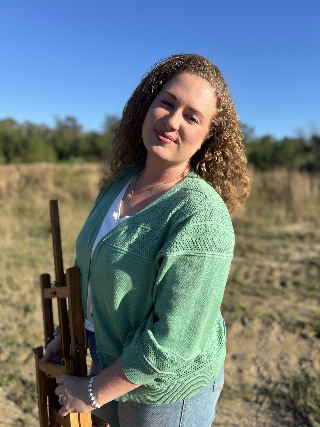 Katie beside her field easel at golden hour