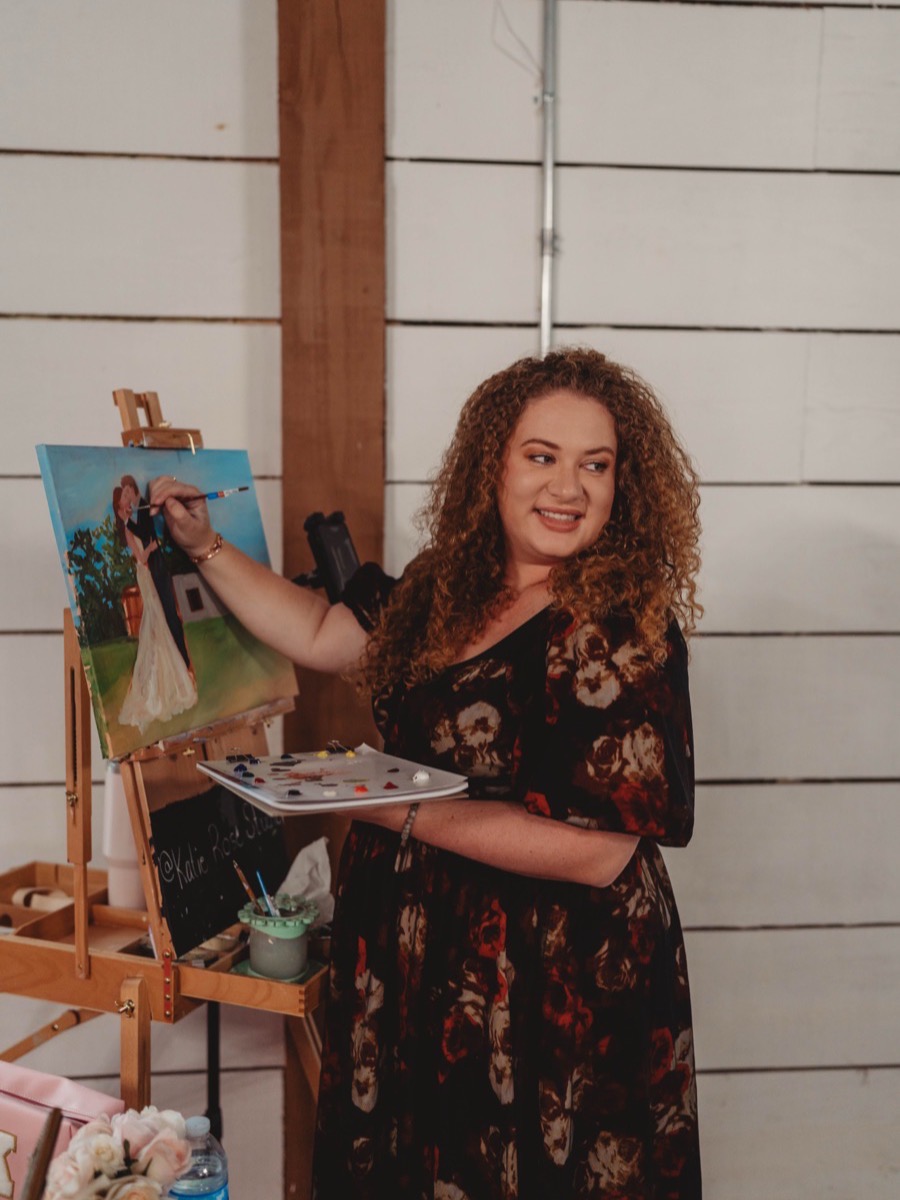 Katie painting a live wedding portrait at her easel