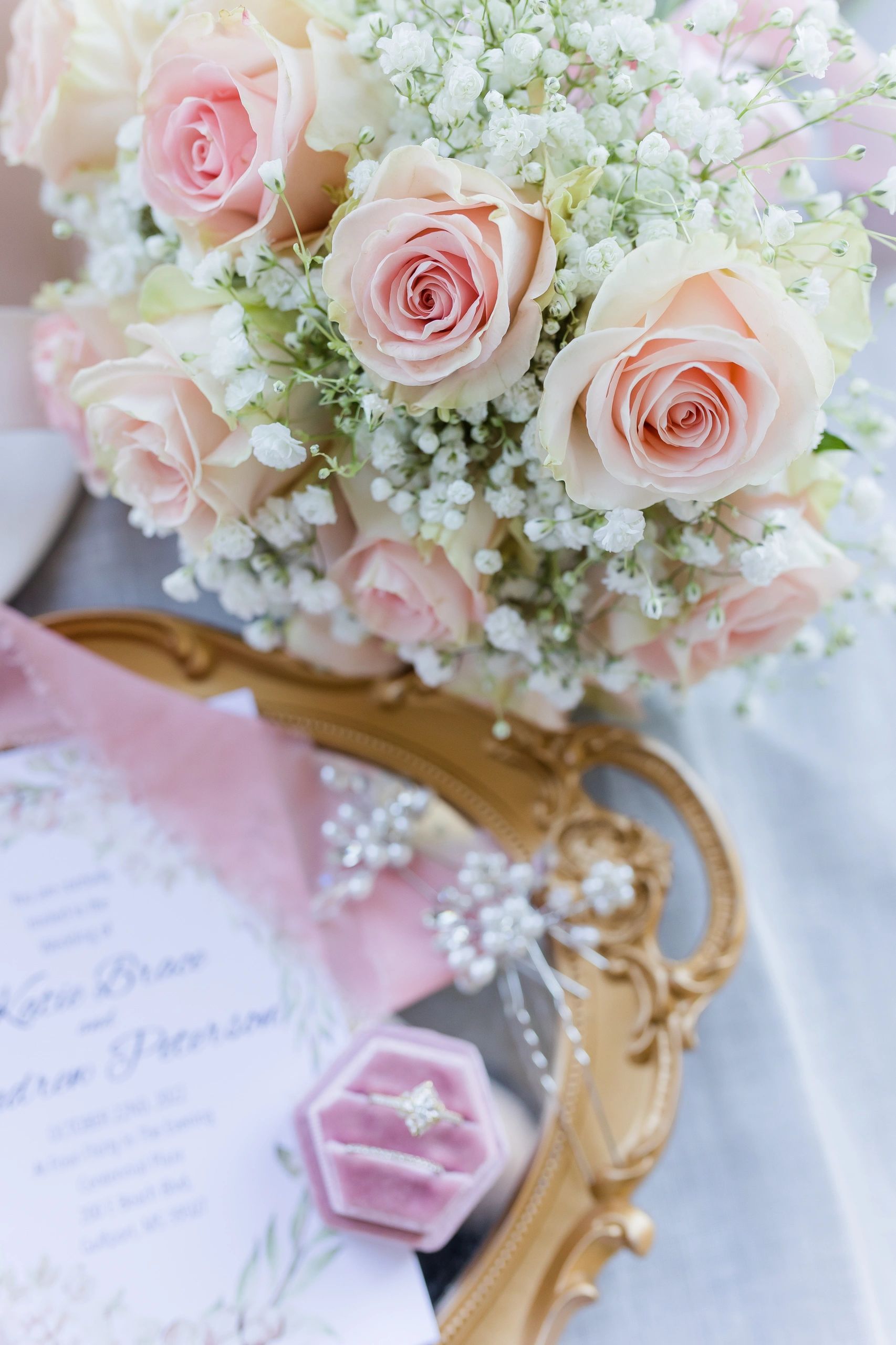 Blush roses, a gold mirror and Katie & Drew's wedding invitation from her own wedding day