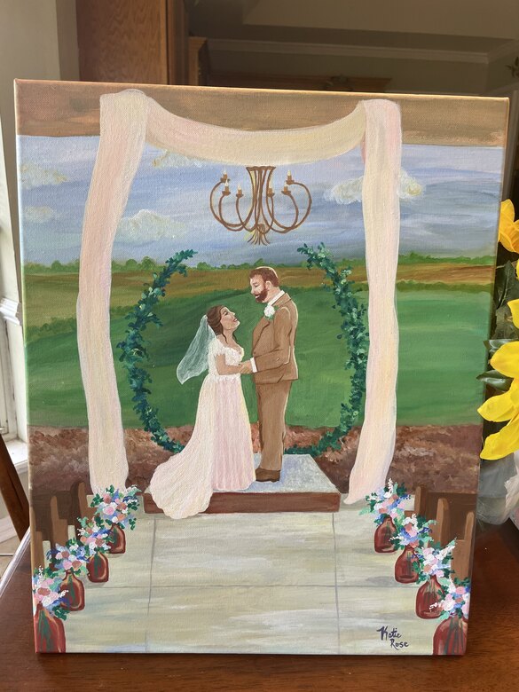 Watercolor of a couple beneath a floral arch