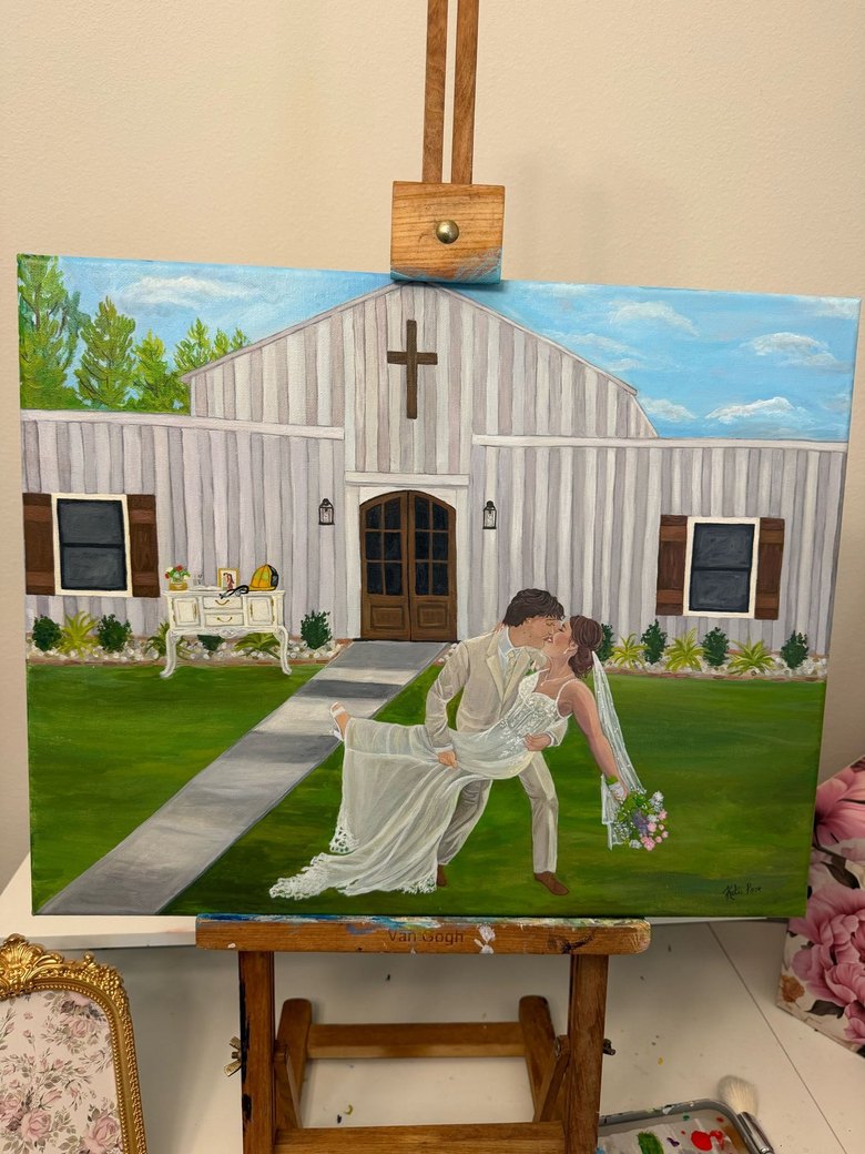 Live wedding painting of a couple's first kiss before a white chapel, on the easel in the studio