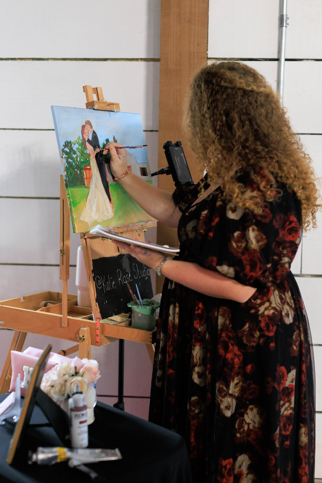 Katie at her easel painting a couple's first dance live at their reception