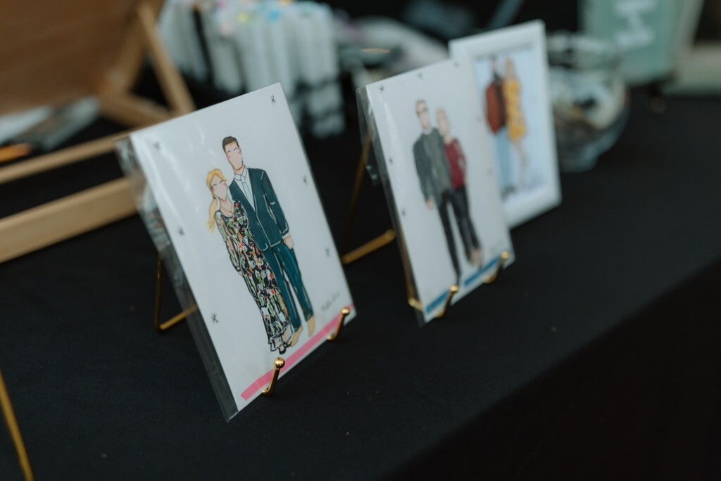 Framed fashion illustrations displayed on easels at one of Katie's events